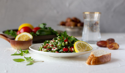 Tabbouleh salad with bread and fresh water with dates. Iftar, evening meal during month of Ramadan.