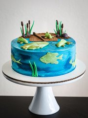 Beautiful blue cake.Water decor.Fish, pond, reeds.Handmade work.White porcelain high stand