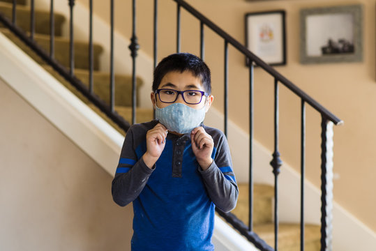 Asian boy in glasses wearing cloth mask