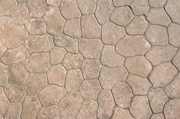 The texture of the light brown stone pavement.