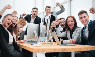 group of happy office employees sitting at a table.