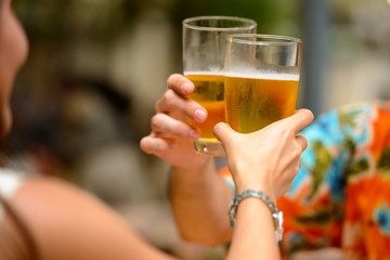 Happy multi ethnic tourist couple drinking beer together at restaurant