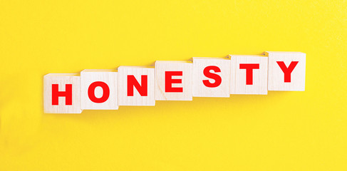 HONESTY is a word on red wooden cubes on a yellow background