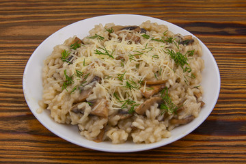 Tasty appetizing risotto on  white plate on  wooden table