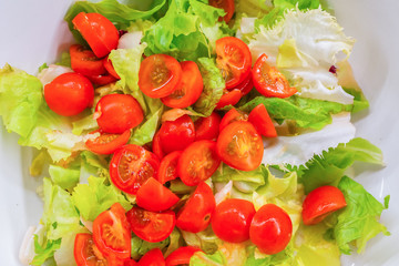 Salad with lettuce and cherry tomatoes close up.