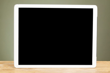 Digital tablet computer with isolated screens on old wooden desk.