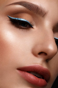 Beautiful girl with sexy lips and classic makeup with cosmetic blue eyeliner . Beauty face.