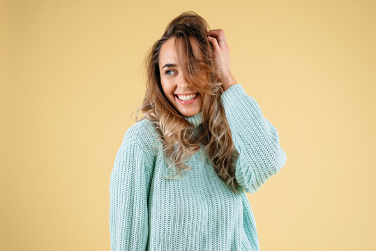 Beautiful standing woman model posing and smiling solated on a yellow background