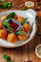 cheese balls on a plate with sauce close up