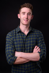 Portrait of happy young handsome hipster man smiling with arms crossed