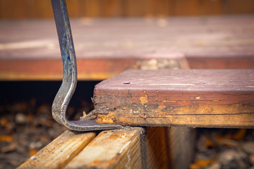 Flat pry bar lifting of a rotten plank off a deck construction