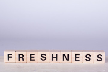 wooden cubes building the word Freshness, white background
