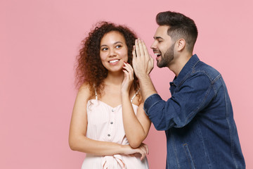 Funny young couple friends european guy african american girl in casual clothes isolated on pastel...