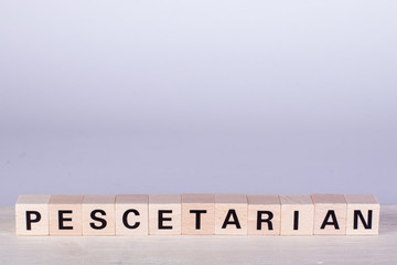 wooden cubes building the word Pescetarian, white background