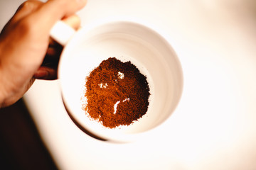 Dissatisfied anthropomorphic face formed of coffee ground in mug. Bad morning