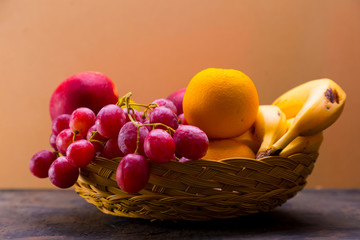 Apples, oranges, grapes, bananas in a basket.