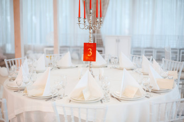 White table with plates knives, forks and napkins.
