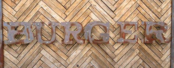 The inscription "Burger" on a wooden background. Old vintage "Burger" sign
