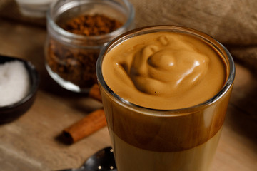Dalgona coffee - the Korean coffee drink on wooden background. Instant coffee or espresso powder whipped with sugar and hot water. Iced whipped dalgona coffee concept.