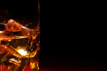 Ice in a glass of whiskey side view. Close up