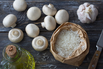 Ingredients for a delicious vegan dish. White basmati rice, garlic and champignons on a wooden table, top view, horizontal	