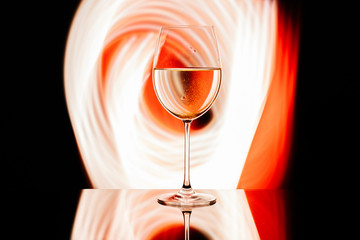 Glass for wine against the backdrop of bright color solutions 