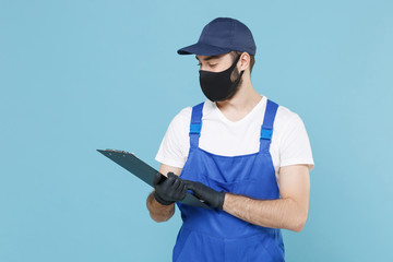 Delivery man in cap t-shirt uniform mask gloves isolated on blue background studio. Guy employee courier hold clipboard papers document Service quarantine coronavirus virus covid-19 2019-ncov concept.