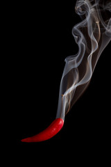 Red pepper pouring smoke on black background