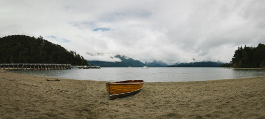 wooden boat at the shore of the lake