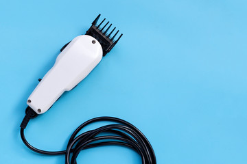 Electric hair clipper on blue background.
