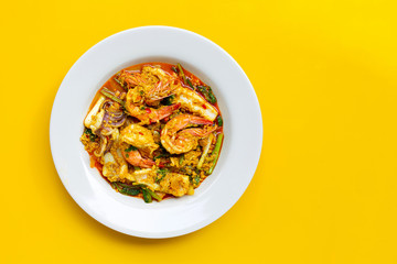 Fried seafood with curry powder on yellow background.