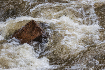 Rushing water around pointy rock