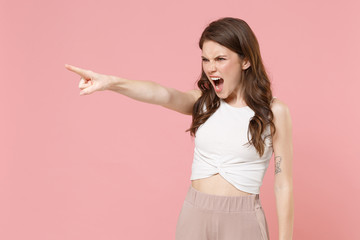 Irritated young brunette woman girl in light casual clothes posing isolated on pastel pink...