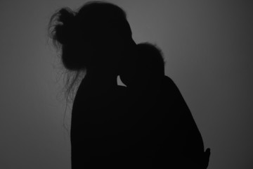 Silhouette Of Happy Mother and Baby. Mom and baby hugging to eachother, Happy Mother's Day concept