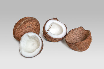 Split coconut halves on a light gray background