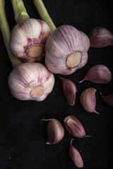 Garlic. Three cut heads of garlic on a dark background