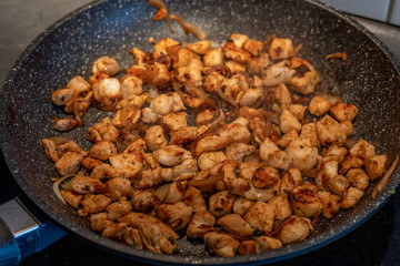 Pieces of chicken fried in a frying pan