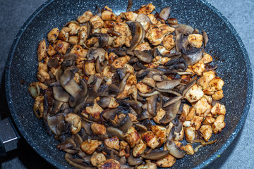 chicken with champignons and onion on a pan