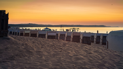 sunset over a sandy beach with beach baskets on the Baltic Sea