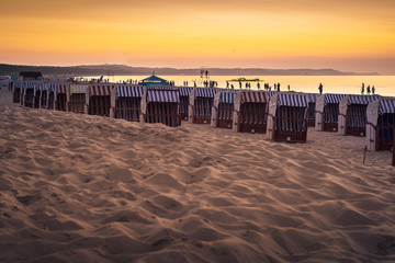 Fototapeta Piaszczysta plaża z koszami plażowymi nad morzem Bałtyckim o zachodzie słońca obraz