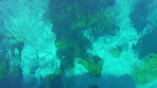 Looking down into the weed and sand of the flowing turquoise and green hypnotic waters of Azmak river in Akyaka, Gokova plain, Mugla, Turkey