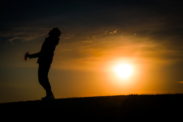 Fototapeta na wymiar 夕暮れの丘に立つ男性のシルエット