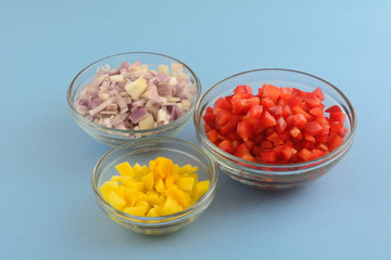 Fresh raw chopped mango, red bell pepper and shallot onion salsa ingredients in glass bowls