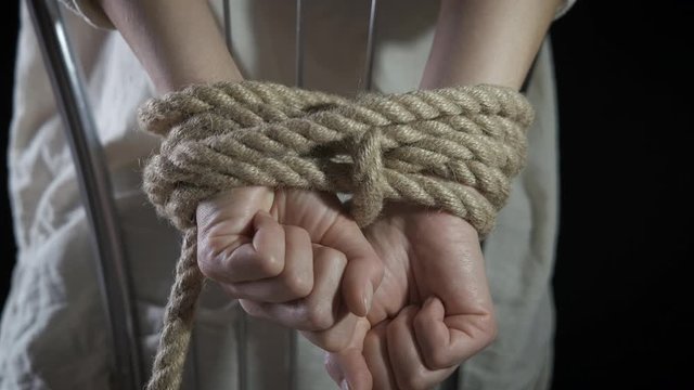 Hostage. The hands of the women are tied at the back. Trafficking in women concept.