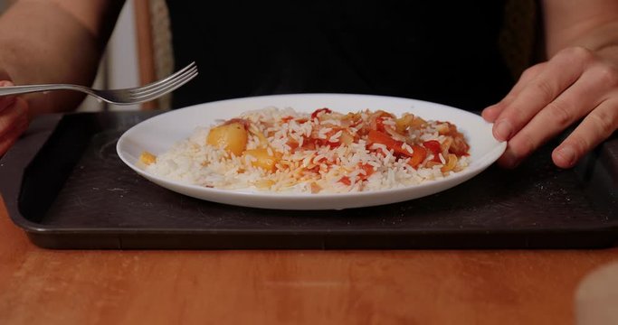 Eating lecho (letsho, lecso) with rice, food made mainly of peppers, tomatos and onions