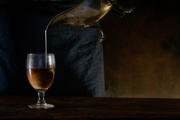 jarra de plata con leche en copa con cafe