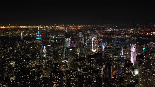 Aerial shot of New York City above East river showing Manhattan by night