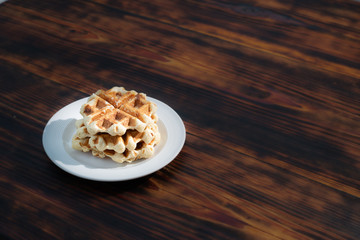 belgian waffle over a white plate with sugar