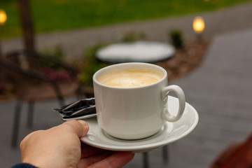 Mug of coffee in a summer cafe. Luxury rest.