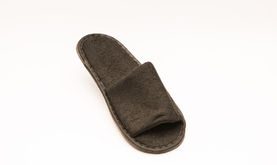 Comfy plush hotel amenity slippers isolated against white background.  